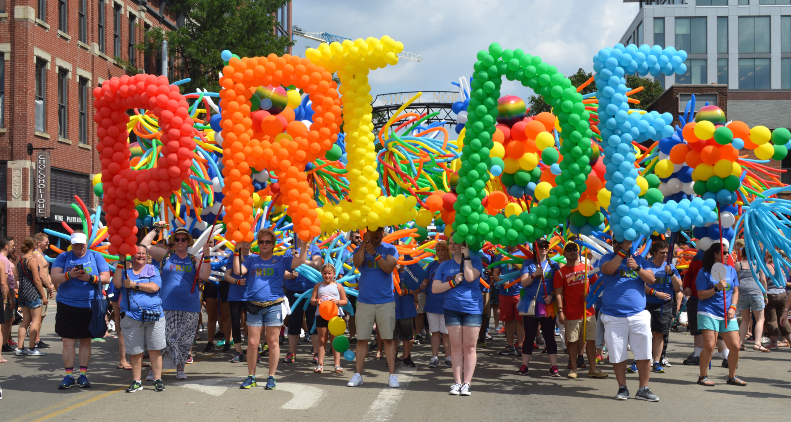 People at a pride parade holding balooons that